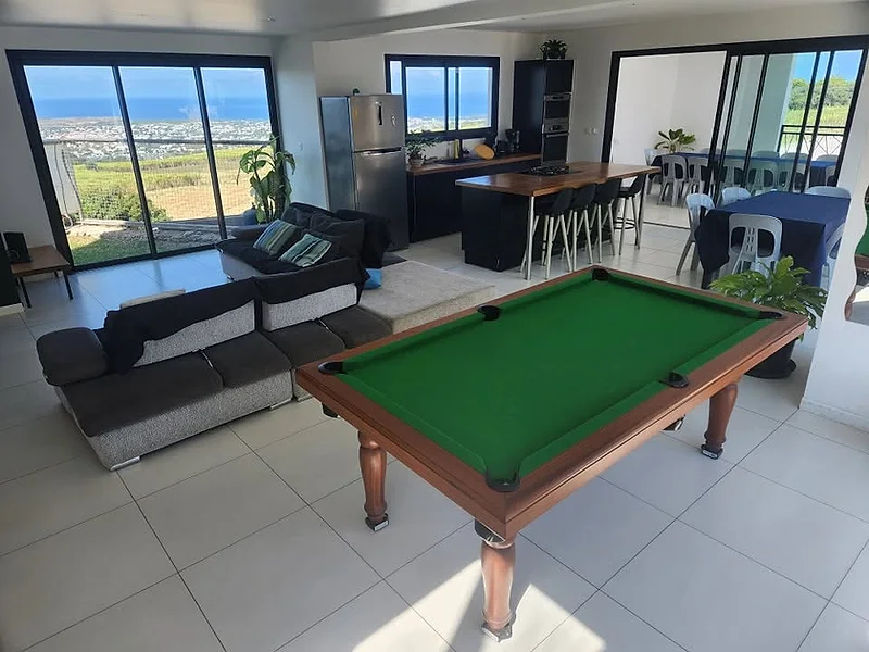 Le séjour avec le billard, la mer derrière les baies vitrées
