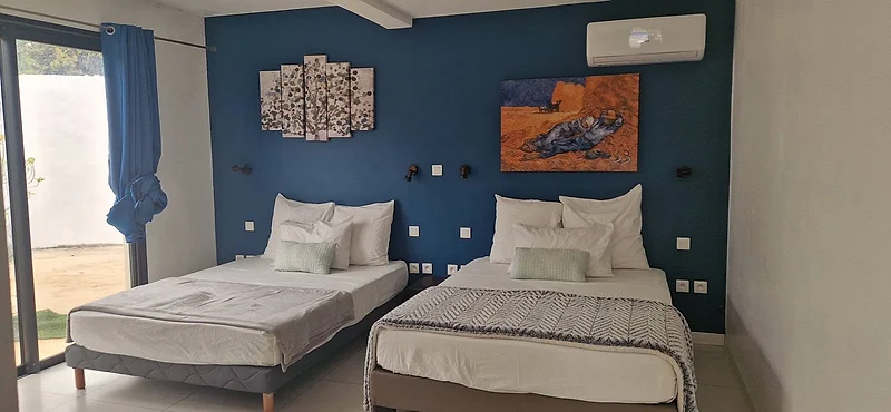 Une chambre avec deux lits et ses tableaux