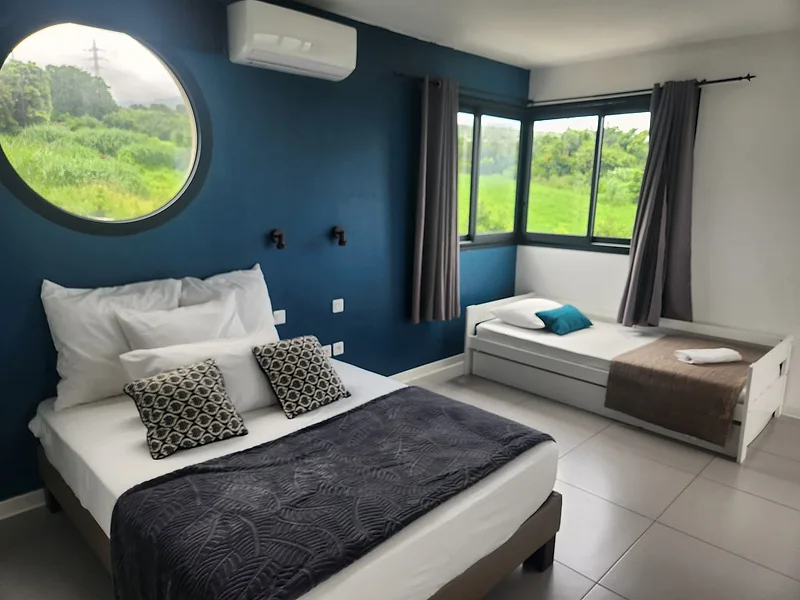 La chambre et sa fenêtre ronde, comme les hublots de la façade, ouverte sur la verdure