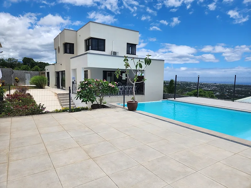 La terrasse dallée et la piscine au pied de la villa