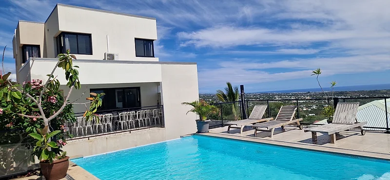 La villa et sa piscine à débordement l'après-midi, l'océan au fond