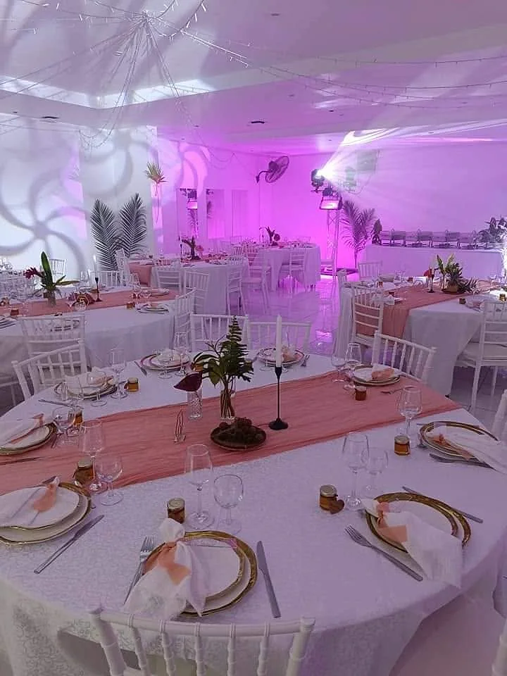 La salle du sous-sol dressée pour une soirée, en lumière rose